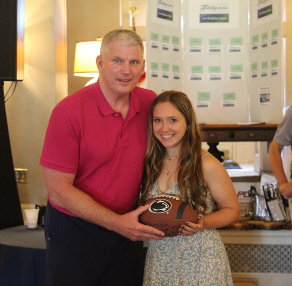 Mike and Vanessa posing with a Penn State football